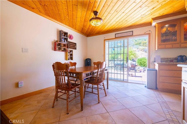 tiled dining area featuring ornamental molding and wood ceiling