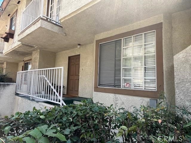 view of exterior entry featuring a balcony