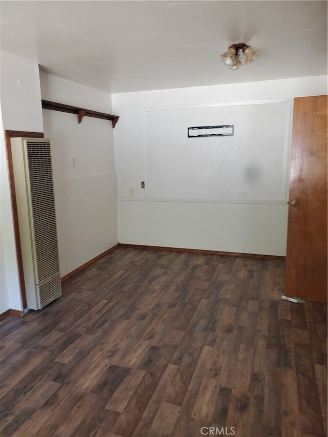 unfurnished room with dark hardwood / wood-style flooring