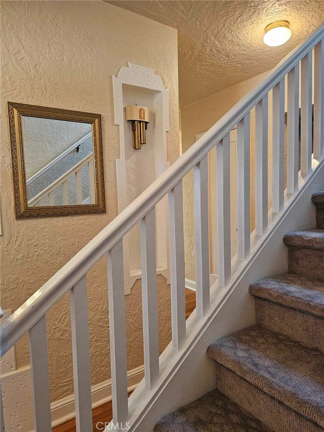 stairs with a textured ceiling