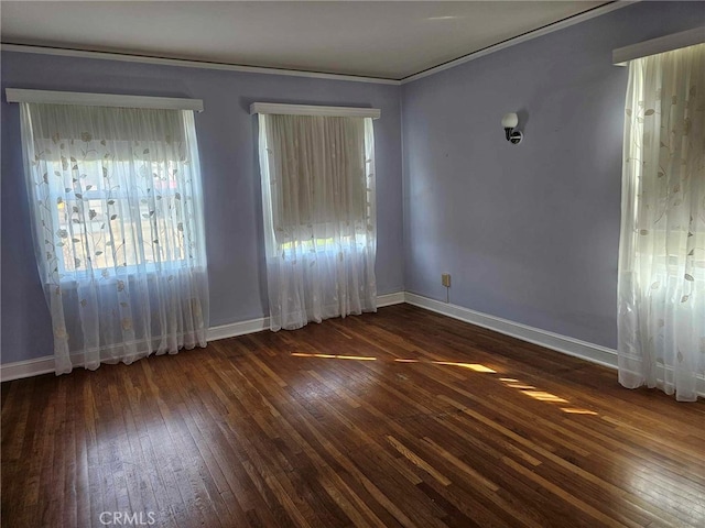 empty room with dark hardwood / wood-style flooring and ornamental molding