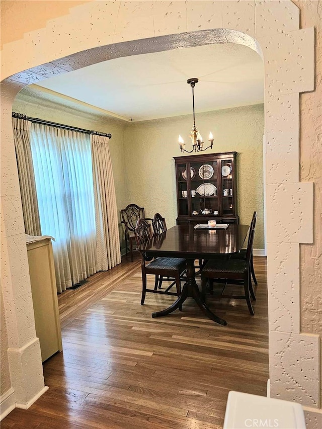 dining space featuring hardwood / wood-style floors and a notable chandelier