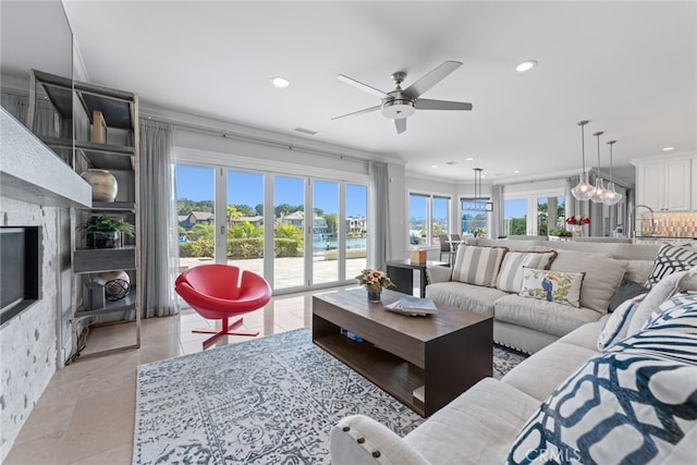 living room featuring ceiling fan with notable chandelier and a healthy amount of sunlight