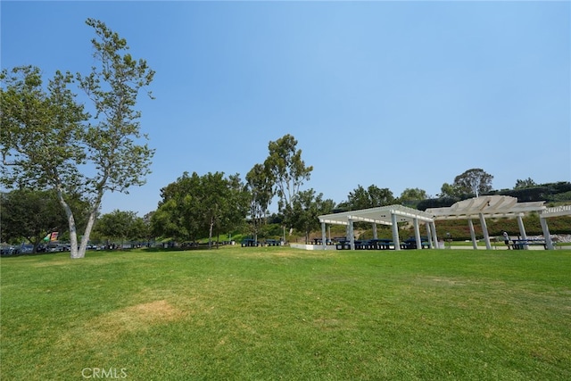 view of community featuring a pergola and a lawn