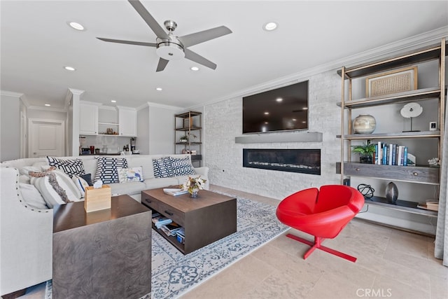 living room featuring ornamental molding, light tile patterned flooring, a large fireplace, and ceiling fan