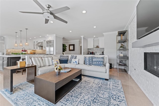 tiled living room with crown molding, a fireplace, and ceiling fan