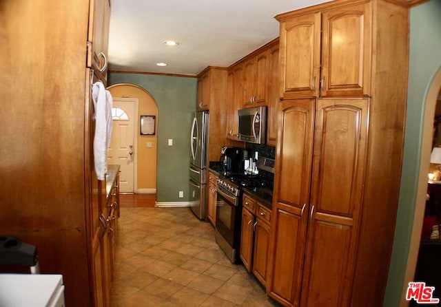 kitchen with crown molding, appliances with stainless steel finishes, and decorative backsplash