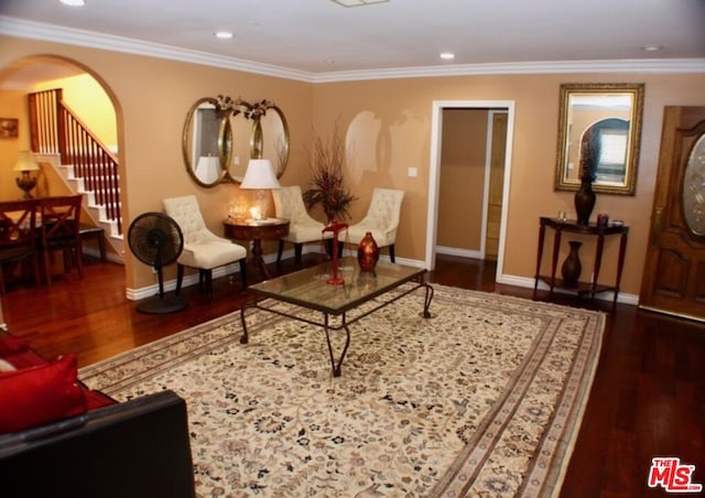 sitting room with ornamental molding and dark wood-type flooring