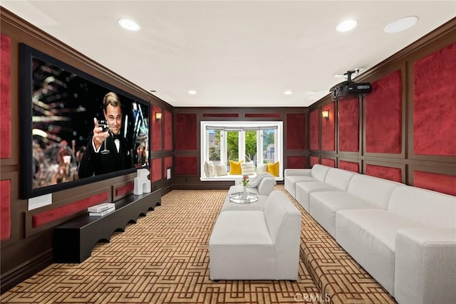 carpeted home theater featuring crown molding