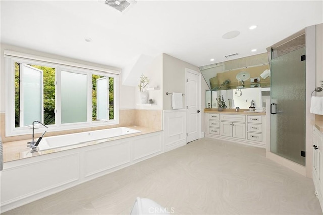 bathroom featuring vanity and independent shower and bath