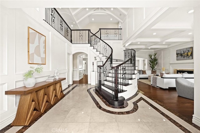 entryway with beamed ceiling, coffered ceiling, and hardwood / wood-style flooring