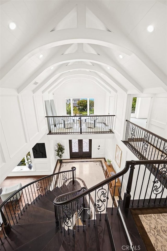 staircase featuring vaulted ceiling with beams, french doors, and hardwood / wood-style flooring