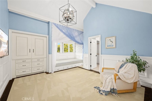 sitting room with vaulted ceiling with beams, carpet floors, and an inviting chandelier