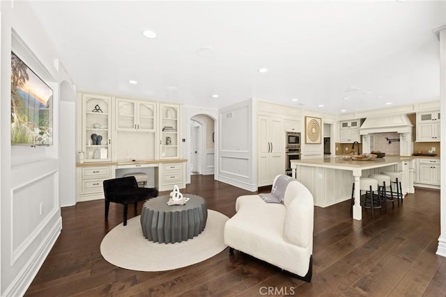 living room with sink and dark wood-type flooring