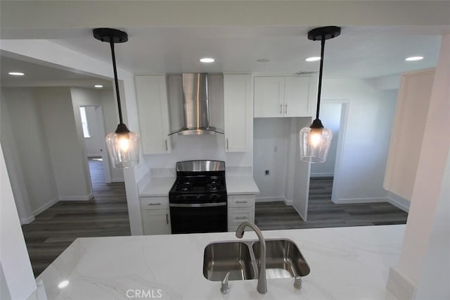 kitchen with white cabinetry, stainless steel gas stove, wall chimney exhaust hood, and pendant lighting