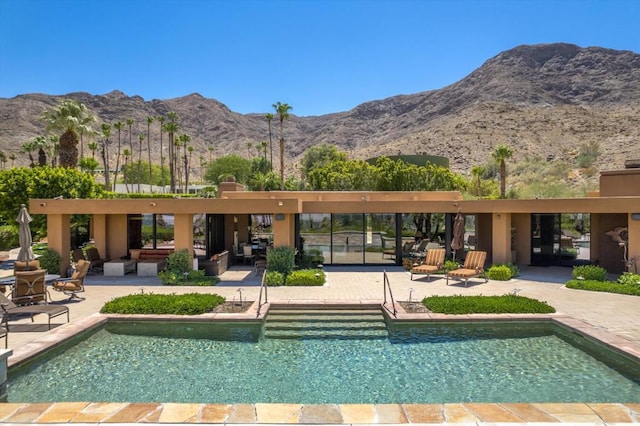 view of pool featuring a mountain view and a patio