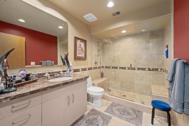 bathroom with tile patterned floors, an enclosed shower, toilet, vanity, and tile walls