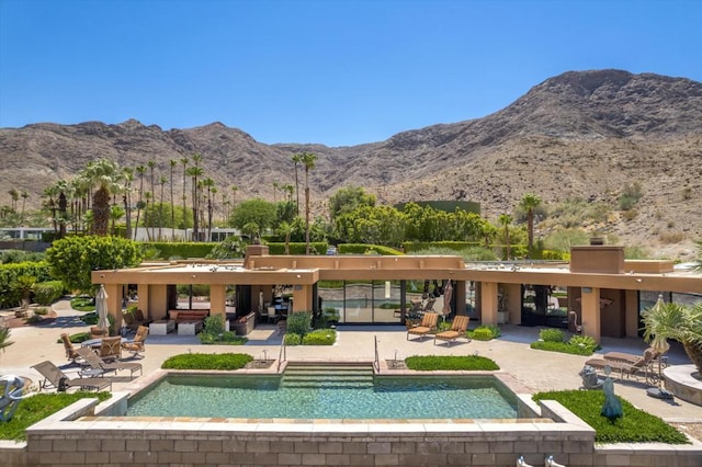 rear view of house featuring a mountain view and a patio