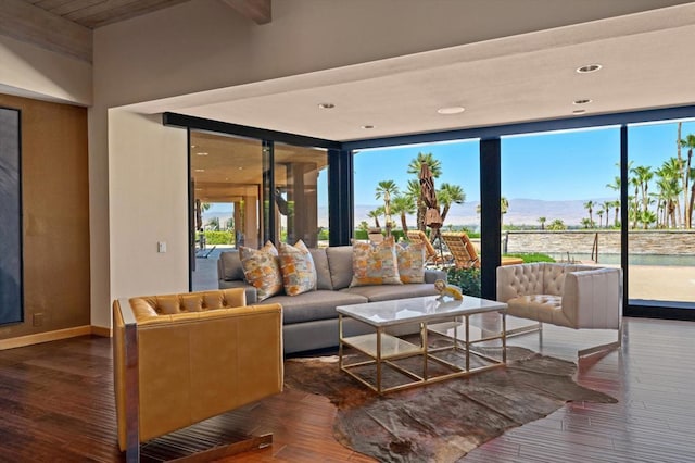 living room with beamed ceiling, a mountain view, and dark hardwood / wood-style flooring