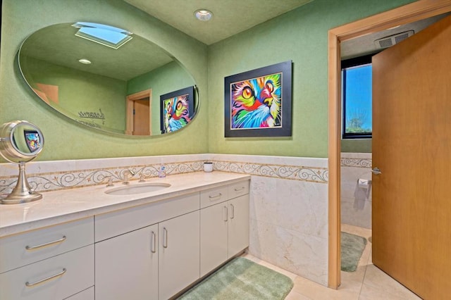 bathroom featuring vanity, tile patterned floors, and tile walls