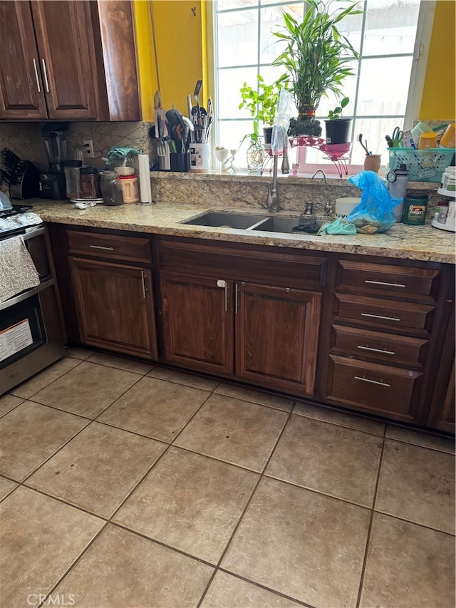 kitchen with sink, dark brown cabinetry, tasteful backsplash, and plenty of natural light