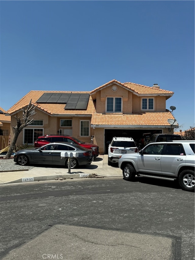 view of front facade featuring a garage and solar panels