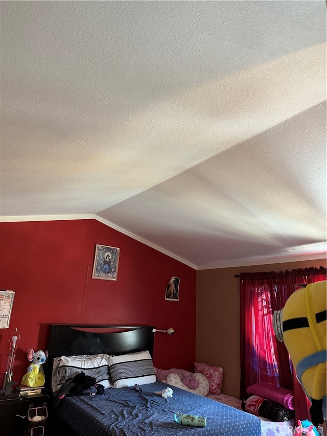 bedroom with lofted ceiling and a textured ceiling