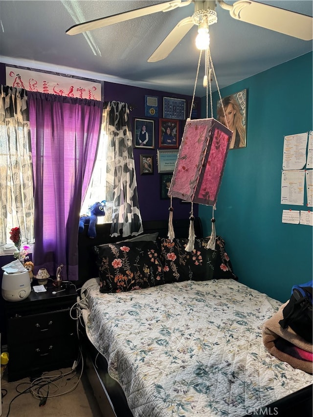 carpeted bedroom with a textured ceiling and ceiling fan