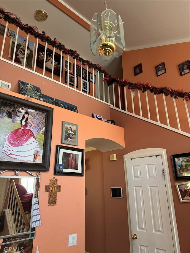 interior space with ornamental molding, vaulted ceiling, and an inviting chandelier