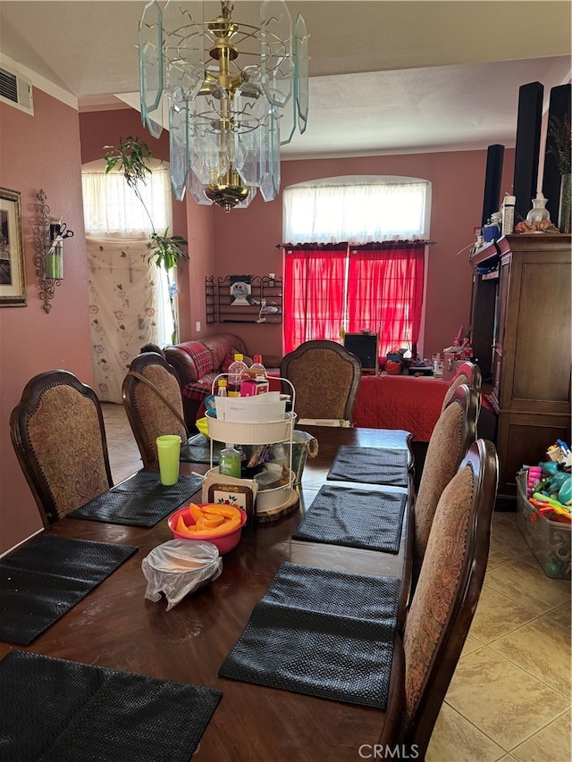 dining room with tile patterned floors and a chandelier