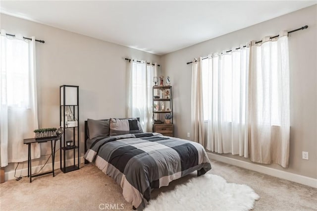 bedroom with carpet floors, multiple windows, and baseboards