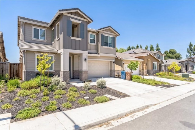 craftsman house featuring driveway, stone siding, an attached garage, fence, and board and batten siding