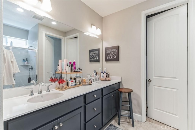 bathroom with double vanity, walk in shower, a sink, and visible vents