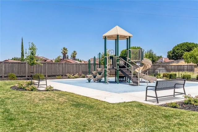 community jungle gym featuring a yard and fence