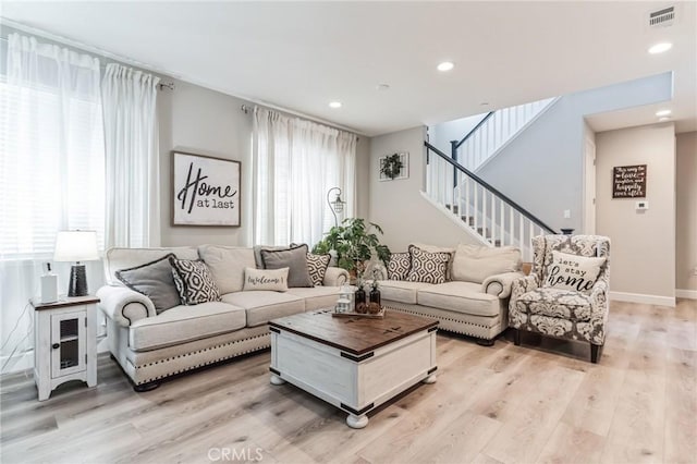 living area featuring recessed lighting, visible vents, baseboards, stairway, and light wood-type flooring