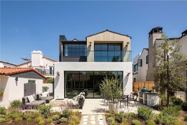 back of property with a balcony and a patio