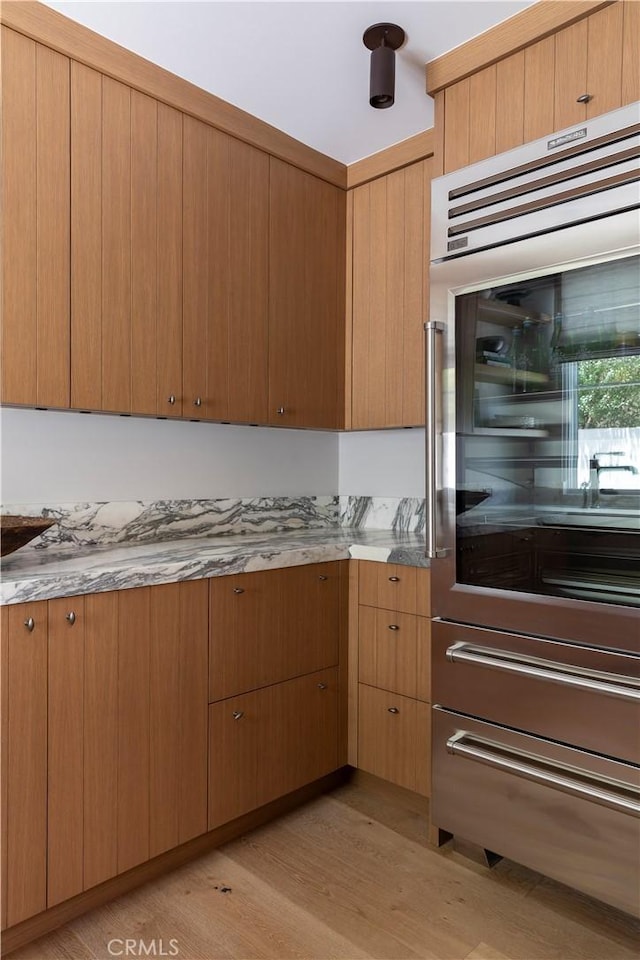 kitchen with light hardwood / wood-style floors and stainless steel double oven