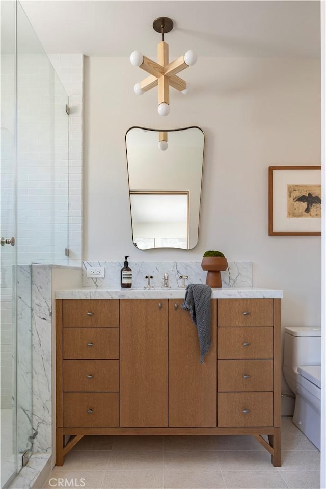 bathroom with tile patterned floors, vanity, toilet, and walk in shower