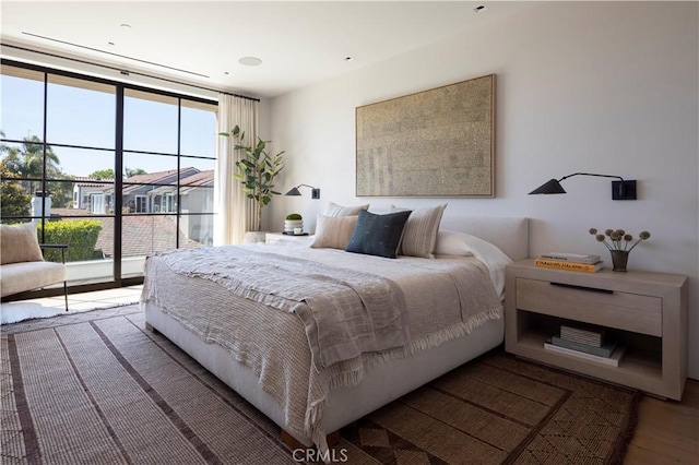 bedroom with access to outside and dark hardwood / wood-style floors