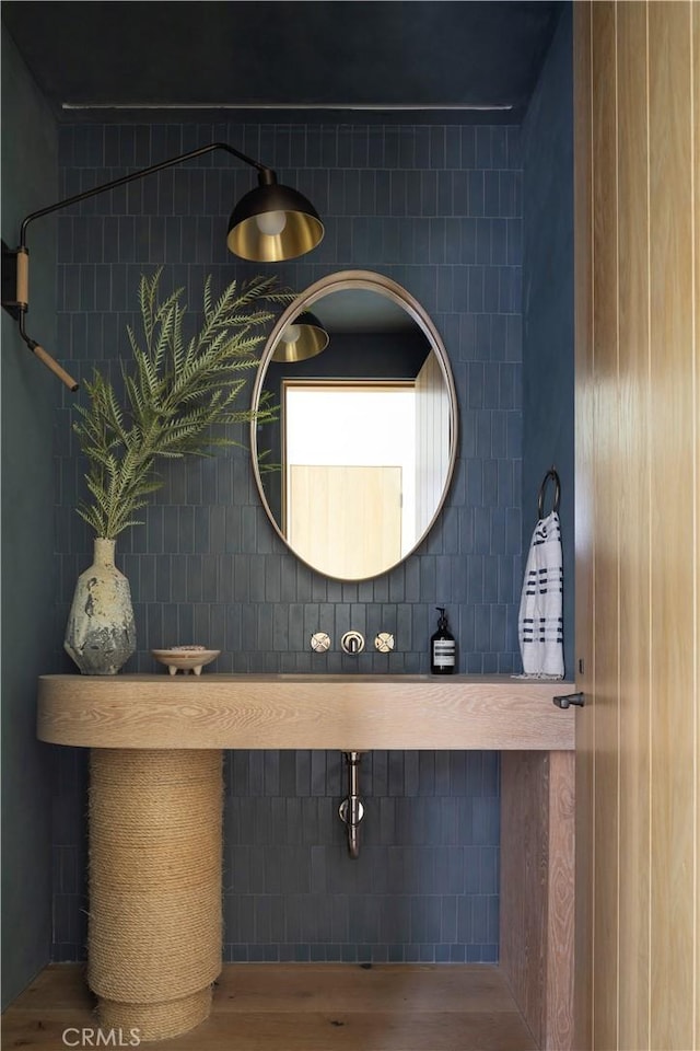 bathroom featuring wood-type flooring and tile walls