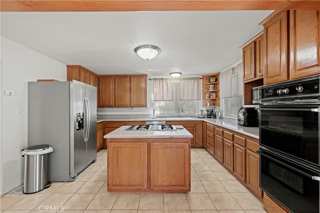 kitchen with appliances with stainless steel finishes, light tile patterned flooring, a kitchen island, and sink