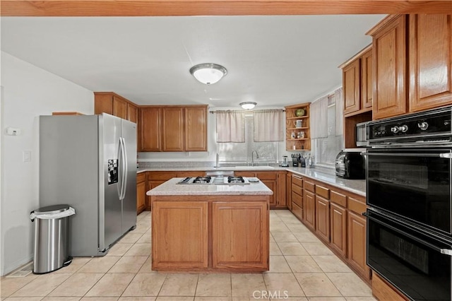 kitchen with stainless steel fridge, dobule oven black, a sink, light countertops, and gas stovetop