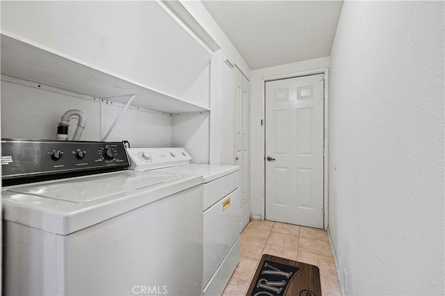 clothes washing area with separate washer and dryer and light tile patterned floors