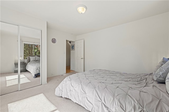 bedroom featuring light colored carpet and a closet