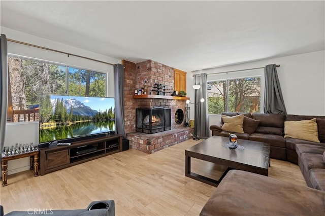 living area featuring a brick fireplace and light wood finished floors