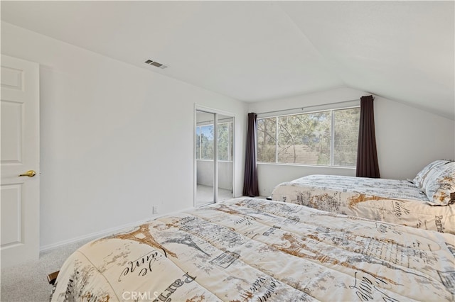 carpeted bedroom featuring vaulted ceiling and a closet