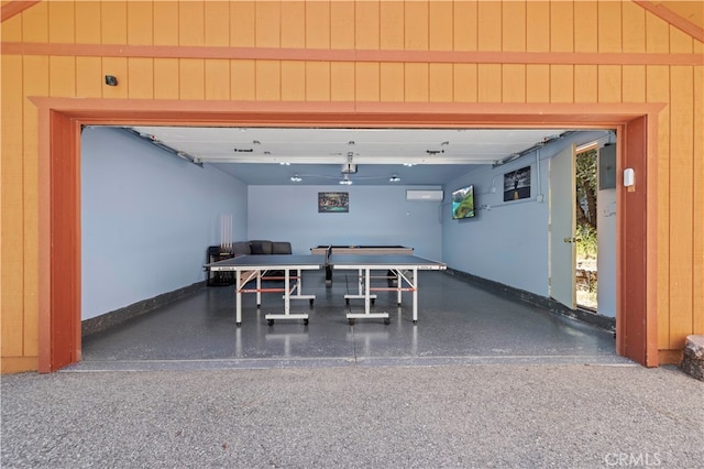 garage featuring wooden walls and a wall unit AC