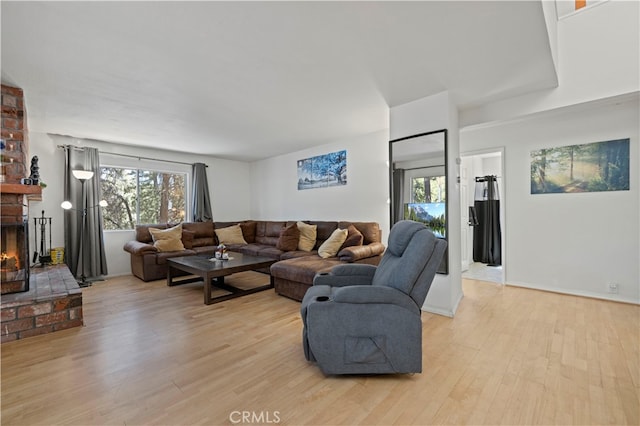 living room with light wood-type flooring and a fireplace