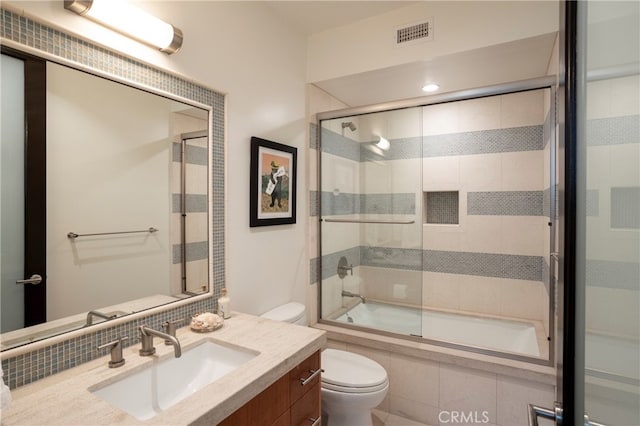 full bathroom featuring bath / shower combo with glass door, toilet, and vanity