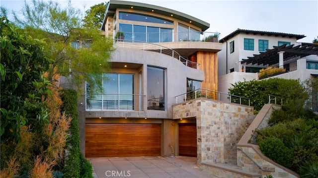 rear view of property with a garage and a balcony